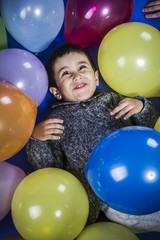 Fototapeta na wymiar boy playing with balloons of many colors