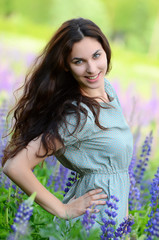 Fototapeta premium The beautiful woman in the field with lupin