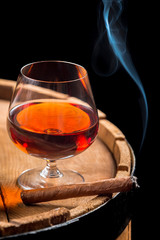 Smoking cigar and wooden brandy barrel