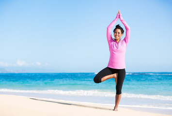Fototapeta na wymiar Boung woman in yoga pose at the beach