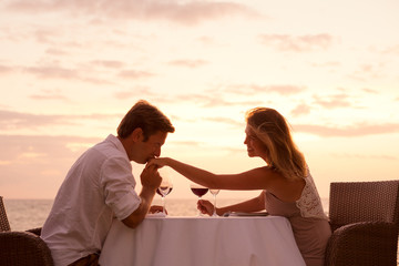 Couple enjoying romantic sunnset dinner on the beach