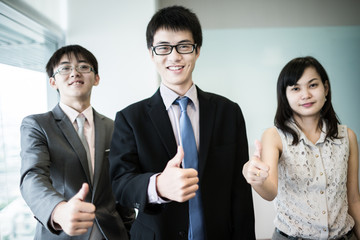 Happy business team with arms crossed at the office