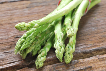Bunch of fresh green asparagus spears on a rustic wooden table