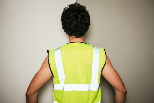 Rear view of builder in high visibility vest