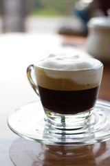 Hot  espresso with milk and foam in cup.