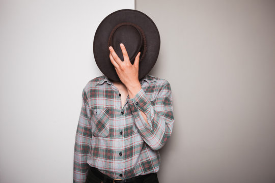 Young cowboy standing against dual colored background