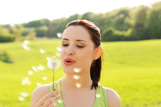 Woman Blowing On A Dandelion