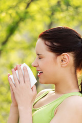 Attractive young woman outdoor with tissue.