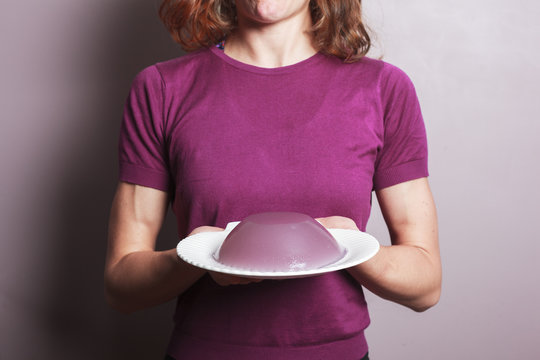 Young woman in purple top with a plate of pudding