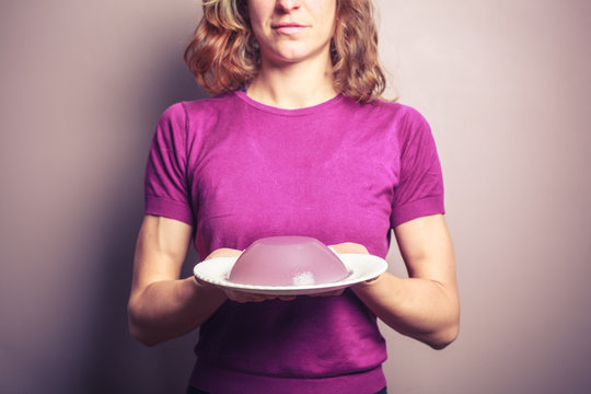 Young woman in purple top with a plate of pudding