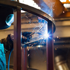 welder with protective mask welding metal and sparks - obrazy, fototapety, plakaty