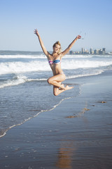 young attractive girl jumping on beach