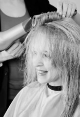 Fototapeta premium Hairdresser dries the hair dryer blond long hair