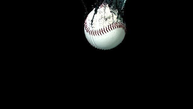 Baseball falling in water on black background