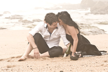 Young attractive couple sharing a moment on beach in the mist