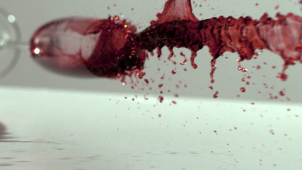 Glass of red wine falling and spilling - Powered by Adobe