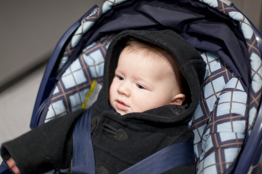 Close-up of a baby boy in a baby carriage