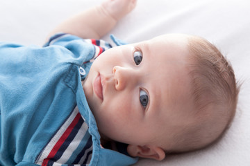 Portrait of a baby boy lying on the bed