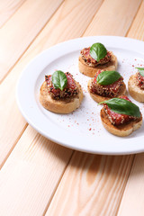 Tasty canapes with salami  and basil leaves,