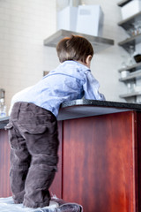 Boy leaning against a kitchen counter