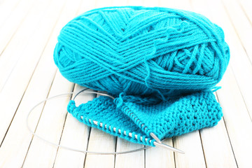 Knitting with spokes on wooden background