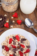 Healthy cereal in bowl with strawberries and chocolate