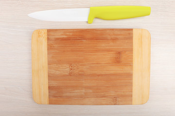 Kitchen knife and cutting board on wooden table