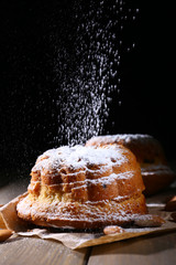 Tasty cakes on table on black background