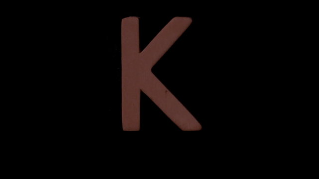 The letter k rising on black background