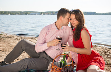 happy young couple enjoying picnic on the beach