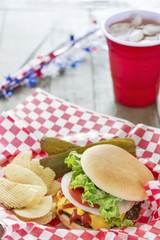 Loaded cheeseburger with ice tea at a barbecue