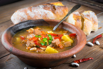 .Hungarian goulash with beans and peppers on wooden board