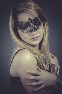 Beautiful blonde with silver jewelry and mask