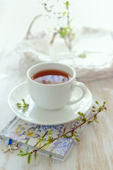 Сup of tea and blooming twig