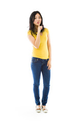 Fototapeta premium Young Asian woman standing with finger on lips