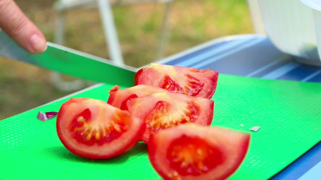Woman slicing tomatoes on a cutting board.