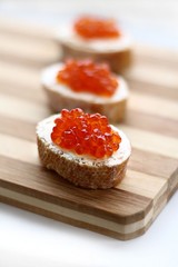Red caviar in spoon on a baguette