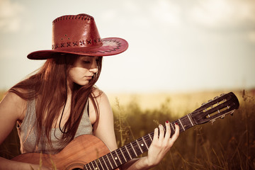 brunet woman playing old guitar