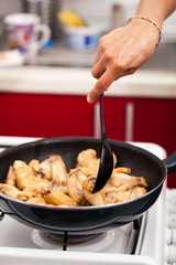 Woman cooking chicken wings