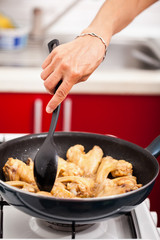 Woman cooking chicken wings