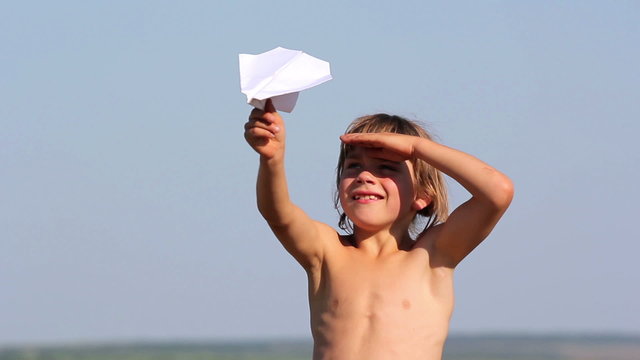 Boy launches a paper airplane.