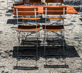 Wooden chairs and tables in park cafe