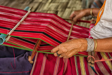 Woman working at the loom. thai national crafts. Focus on the fa