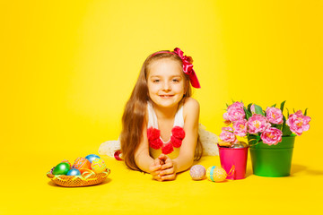 Obraz na płótnie Canvas Beautiful girl lying on floor with tulips, eggs