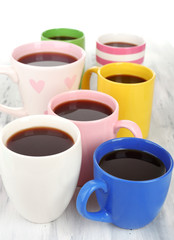 Many cups of coffee on wooden table close up