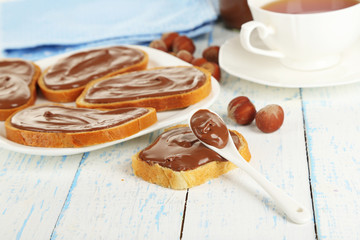 Bread with sweet chocolate hazelnut spread on plate on table