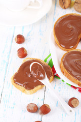 Bread with sweet chocolate hazelnut spread on plate on table