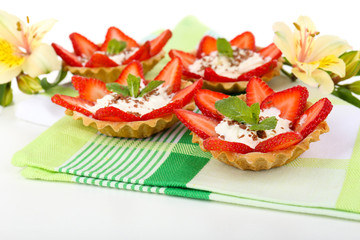 Tasty tartlets with strawberries on table close-up