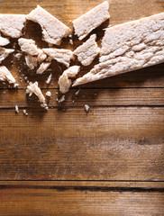 Crushed dietic rye bread on wooden background