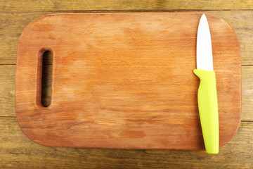Kitchen knife and cutting board on wooden table